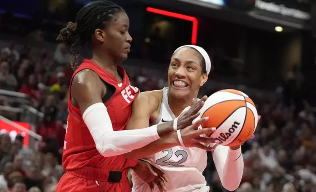 Las Vegas Aces' A'ja Wilson (22) goes to the basket against Indiana Fever's Temi Fagbenle (14) during the second half of a WNBA basketball game, Wednesday, Sept. 11, 2024, in Indianapolis. (AP Photo/Darron Cummings)