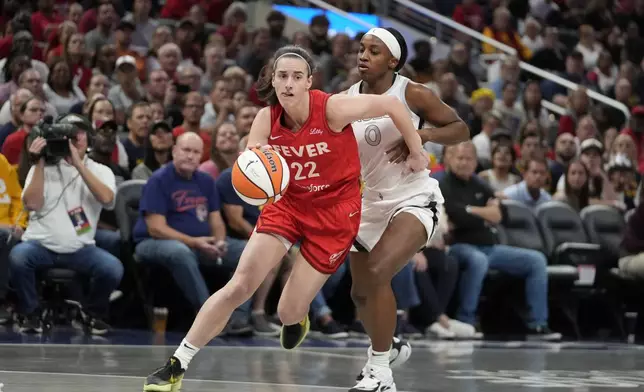 Indiana Fever's Caitlin Clark (22) goes to the basket against Las Vegas Aces' Jackie Young (0) during the first half of a WNBA basketball game, Wednesday, Sept. 11, 2024, in Indianapolis. (AP Photo/Darron Cummings)