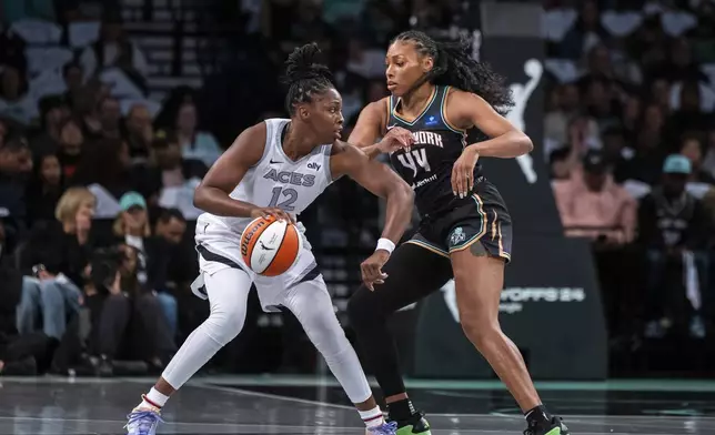 Las Vegas Aces guard Chelsea Gray (12) is defended by New York Liberty forward Betnijah Laney-Hamilton (44) during the first half of a WNBA basketball second-round playoff game, Sunday, Sept. 29, 2024, in New York. (AP Photo/Corey Sipkin)