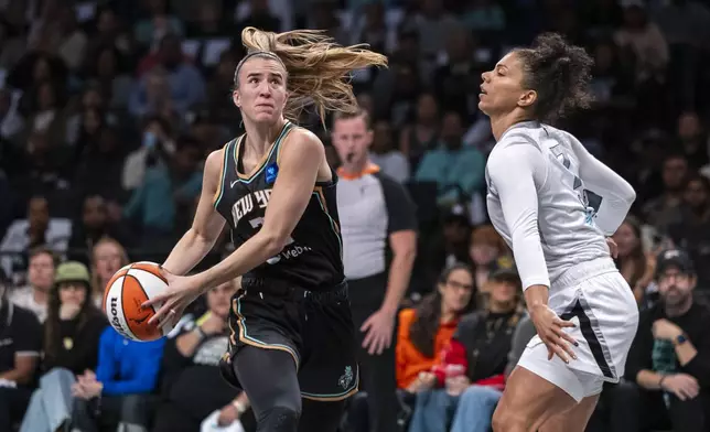 New York Liberty guard Sabrina Ionescu, left, is defended by Las Vegas Aces forward Alysha Clark, right, during the first half of a WNBA basketball second-round playoff game, Sunday, Sept. 29, 2024, in New York. (AP Photo/Corey Sipkin)