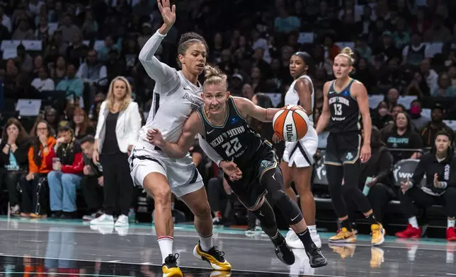 New York Liberty guard Courtney Vandersloot (22) is defended by Las Vegas Aces forward Alysha Clark, left, during the first half of a WNBA basketball second-round playoff game, Sunday, Sept. 29, 2024, in New York. (AP Photo/Corey Sipkin)