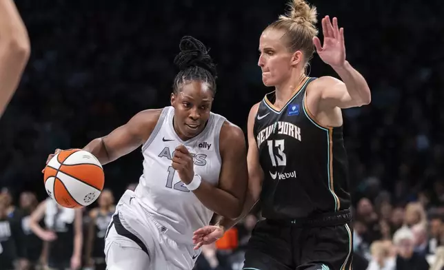 Las Vegas Aces guard Chelsea Gray (12) is defended by New York Liberty forward Leonie Fiebich (13) during the second half of a WNBA basketball second-round playoff game, Sunday, Sept. 29, 2024, in New York. (AP Photo/Corey Sipkin)