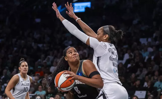 New York Liberty forward Nyara Sabally (8) is defended by Las Vegas Aces center A'ja Wilson (22) during the first half of a WNBA basketball second-round playoff game, Sunday, Sept. 29, 2024, in New York. (AP Photo/Corey Sipkin)