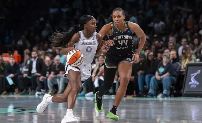 Las Vegas Aces guard Jackie Young (0) drives around New York Liberty forward Betnijah Laney-Hamilton (44) during the second half of a WNBA basketball second-round playoff game, Sunday, Sept. 29, 2024, in New York. (AP Photo/Corey Sipkin)