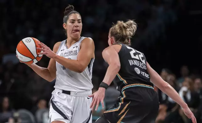 Las Vegas Aces guard Kelsey Plum, left, looks to pass around New York Liberty guard Courtney Vandersloot (22) during the second half of a WNBA basketball second-round playoff game, Sunday, Sept. 29, 2024, in New York. (AP Photo/Corey Sipkin)