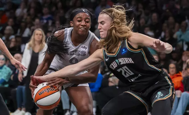 Las Vegas Aces guard Jackie Young (0) is defended by New York Liberty guard Sabrina Ionescu (20) during the second half of a WNBA basketball second-round playoff game, Sunday, Sept. 29, 2024, in New York. (AP Photo/Corey Sipkin)