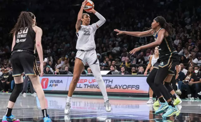 Las Vegas Aces center A'ja Wilson (22) looks to shoot between New York Liberty forwards Breanna Stewart (30) and Jonquel Jones, right, during the second half of a WNBA basketball second-round playoff game, Sunday, Sept. 29, 2024, in New York. (AP Photo/Corey Sipkin)