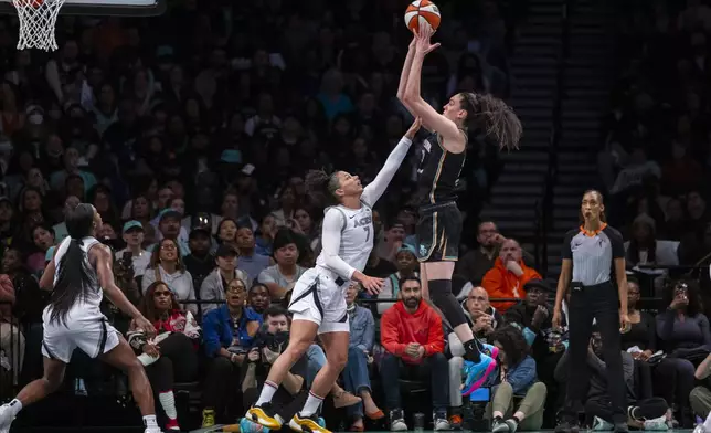 New York Liberty forward Breanna Stewart, center right, shoots over Las Vegas Aces forward Alysha Clark (7) during the second half of a WNBA basketball second-round playoff game, Sunday, Sept. 29, 2024, in New York. (AP Photo/Corey Sipkin)