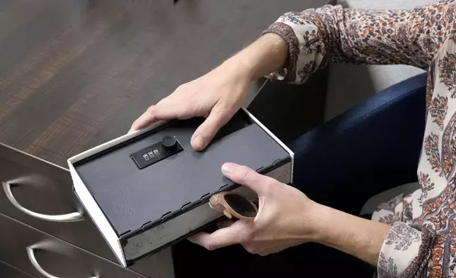 Methadone patient Irene Garnett, 44, of Phoenix, holds her medication lock box at a clinic in Scottsdale, Ariz., on Monday, Aug. 26, 2024. (AP Photo/Ross D. Franklin)