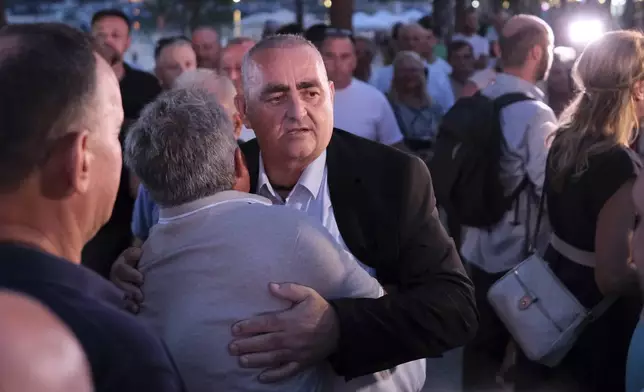 Fredis Beleris, a former ethnic Greek mayor of an Albanian town whose imprisonment on vote-buying charges has strained Albanian-Greek ties, gets a hug from a supporter after his release on probation, in Himara, southwestern Albania, Monday, Sept. 2, 2024. (AP Photo/Vlasov Sulaj)