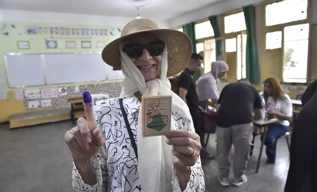 A voter poses for a photo with her inked finger after casting her ballot inside a polling station during the presidential elections, Saturday, Sept. 7, 2024, in Algiers, Algeria. (AP Photo/Fateh Guidoum)