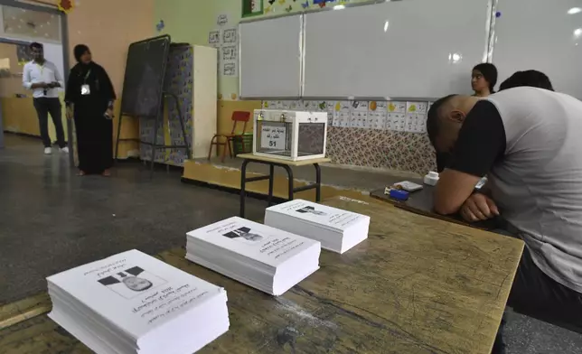 Election officials wait for voters inside a polling station during the presidential election, Saturday, Sept. 7, 2024, in Algiers, Algeria. (AP Photo/Fateh Guidoum)