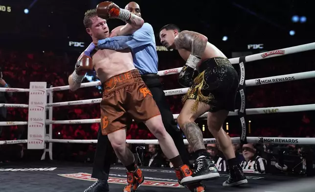 Referee Harvey Dock pulls Canelo Alvarez and Edgar Berlanga apart in their super middleweight title bout Saturday, Sept. 14, 2024, in Las Vegas. (AP Photo/John Locher)