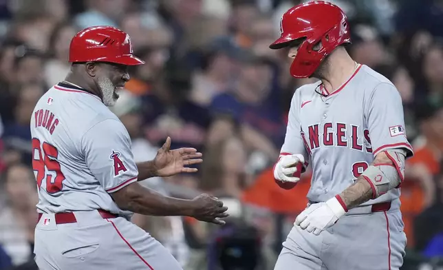 Los Angeles Angels' Zach Neto, right, is congratulated by third base coach Eric Young Sr., left, after hitting a solo home run during the eighth inning of a baseball game against the Houston Astros, Sunday, Sept. 22, 2024, in Houston. (AP Photo/Kevin M. Cox)