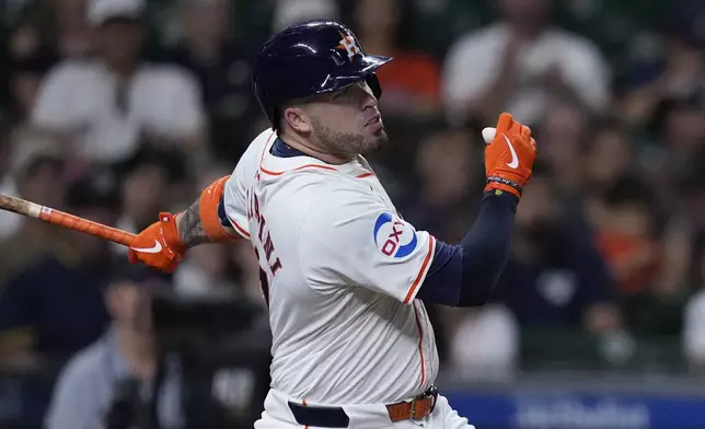 Houston Astros' Victor Caratini hits an RBI single during the fourth inning of a baseball game against the Los Angeles Angels, Thursday, Sept. 19, 2024, in Houston. (AP Photo/Kevin M. Cox)