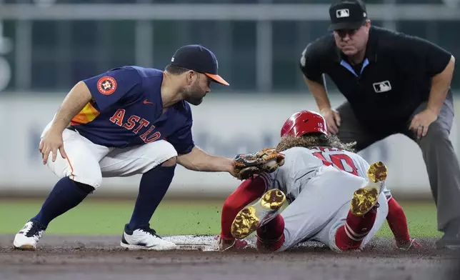 Houston Astros second baseman Jose Altuve, left, catches Los Angeles Angels' Jack López (10) who was trying to steal as umpire Rob Drake, top right, watches for a call during the third inning of a baseball game Sunday, Sept. 22, 2024, in Houston. (AP Photo/Kevin M. Cox)