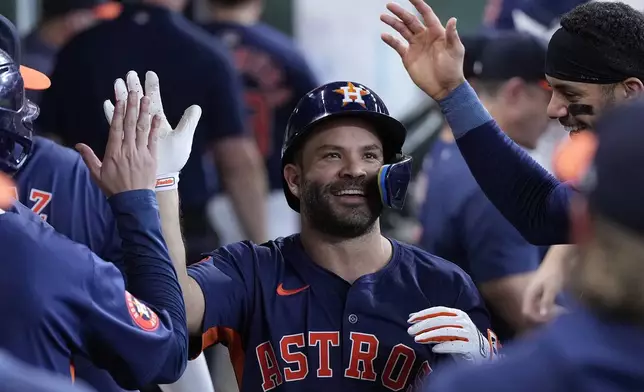 Houston Astros' Jose Altuve is congratulated in the dugout after hitting a solo home run during the fifth inning of a baseball game against the Los Angeles Angels, Sunday, Sept. 22, 2024, in Houston. (AP Photo/Kevin M. Cox)