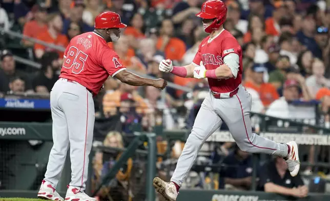 Los Angeles Angels' Logan O'Hoppe, right, celebrates his solo home run against the Houston Astros with third base coach Eric Young Sr. during the fourth inning of a baseball game Saturday, Sept. 21, 2024, in Houston. (AP Photo/Eric Christian Smith)