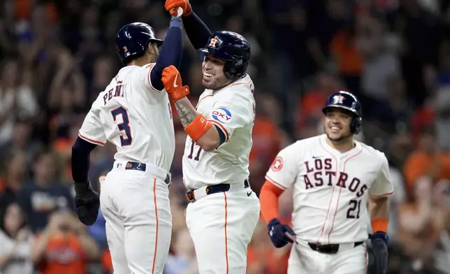 Houston Astros' Victor Caratini, center, celebrates with Jeremy Pena (3) after hitting a three-run home run against the Los Angeles Angels during the third inning of a baseball game, Saturday, Sept. 21, 2024, in Houston. (AP Photo/Eric Christian Smith)