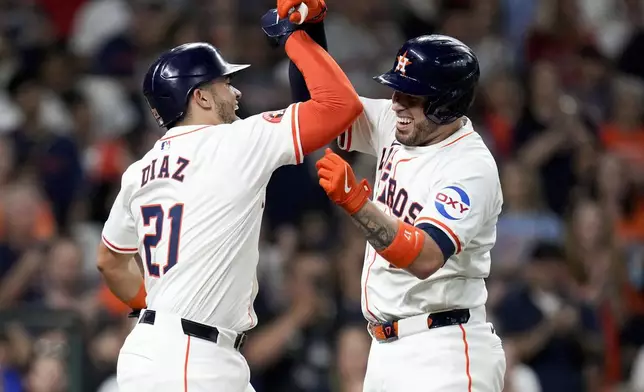 Houston Astros' Victor Caratini, right, celebrates with Yainer Diaz after hitting a three-run home run against the Los Angeles Angels during the third inning of a baseball game, Saturday, Sept. 21, 2024, in Houston. (AP Photo/Eric Christian Smith)