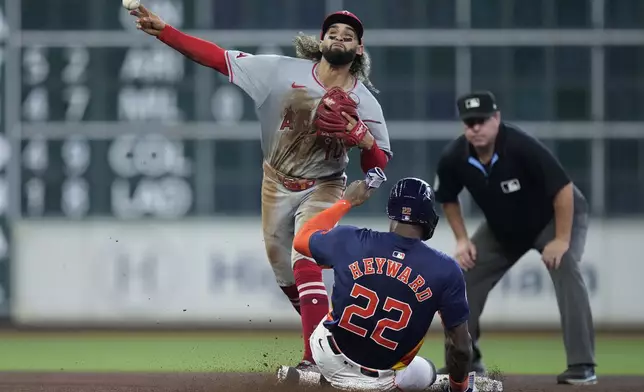 Los Angeles Angels second baseman Jack López (10) turns a double play on Houston Astros' Jake Meyers after forcing out Jason Heyward (22) during the sixth inning of a baseball game Sunday, Sept. 22, 2024, in Houston. (AP Photo/Kevin M. Cox)