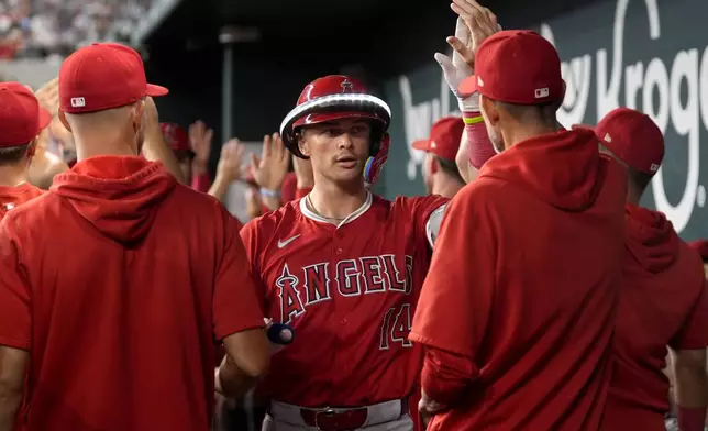 Los Angeles Angels' Logan O'Hoppe (14) celebrates in the dugout after hitting a three-run home run against the Texas Rangers in the sixth inning of a baseball game Friday, Sept. 6, 2024, in Arlington, Texas. (AP Photo/Tony Gutierrez)