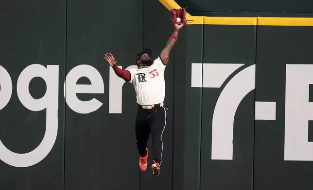 Texas Rangers right fielder Adolis Garcia makes a leaping catch on a fly out by Los Angeles Angels' Nolan Schanuel in the first inning of a baseball game, Friday, Sept. 6, 2024, in Arlington, Texas. (AP Photo/Tony Gutierrez)