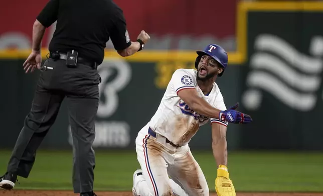 Texas Rangers' Leody Taveras pleads with umpire Sean Barber, left, after being called out attempting to steal second against the Los Angeles Angels in the second inning of a baseball game Thursday, Sept. 5, 2024, in Arlington, Texas. (AP Photo/Tony Gutierrez)