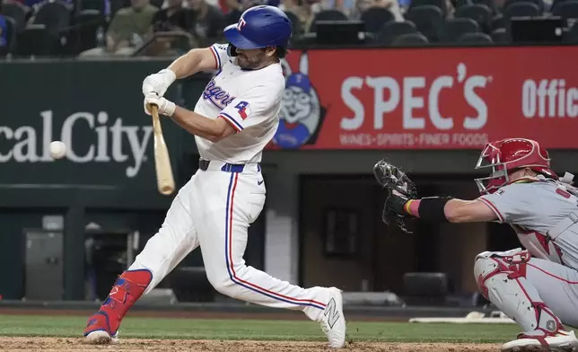 Texas Rangers' Josh Smith, left, hits a single in front of Los Angeles Angels catcher Logan O'Hoppe, right, that scored Carson Kelly and Marcus Semien during the seventh inning of a baseball game Saturday, Sept. 7, 2024, in Arlington, Texas. (AP Photo/LM Otero)