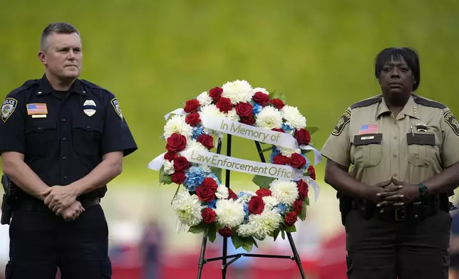 First responders stand with a wreath in memory of law enforcement officers lost on 9/11 before of a baseball game between the Los Angeles Angels and Minnesota Twins, Wednesday, Sept. 11, 2024, in Minneapolis. (AP Photo/Abbie Parr)