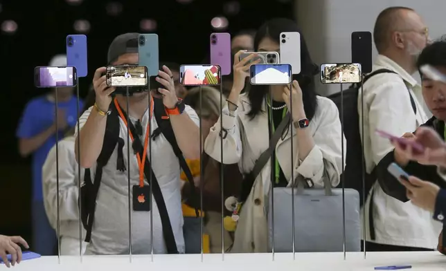 Attendees take a closer look at the Apple iPhone 16 during an announcement of new products at Apple headquarters Monday, Sept. 9, 2024, in Cupertino, Calif. (AP Photo/Juliana Yamada)