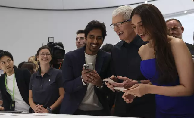 Apple CEO Tim Cook, second from right, smiles as he shows the new iPhone 16 model to attendees at Apple headquarters Monday, Sept. 9, 2024, in Cupertino, Calif. (AP Photo/Juliana Yamada)