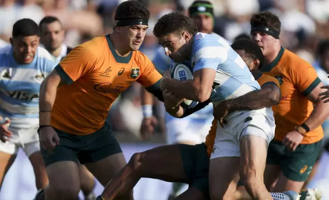 Argentina's Los Pumas Juan Cruz Mallia, center, is tackled by Australia's Marika Koroibete, second right, during a rugby championship test match in Santa Fe, Argentina, Saturday, Sept. 7, 2024. (AP Photo/Mateo Occhi)