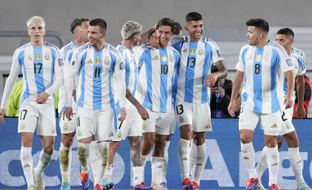 Teammates surround Argentina's Paulo Dybala (10) after he scored his side's third goal against Chile during a qualifying soccer match for the FIFA World Cup 2026 in Buenos Aires, Argentina, Thursday, Sept. 5, 2024. (AP Photo/Natacha Pisarenko)