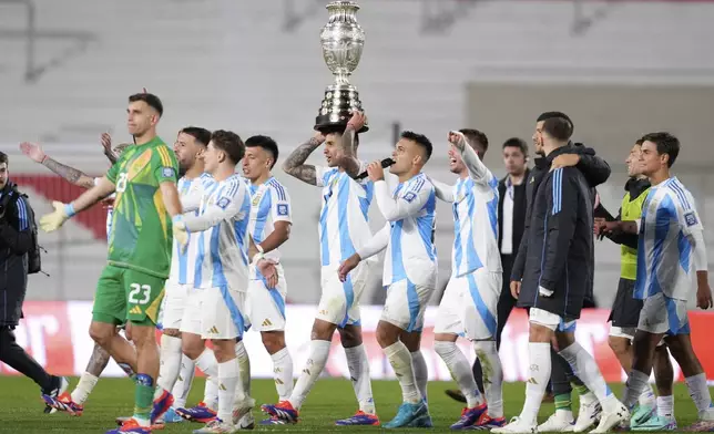 Players of Argentina display the 2024 Copa America trophy after a qualifying soccer match for the FIFA World Cup 2026 against Chile in Buenos Aires, Argentina, Thursday, Sept. 5, 2024. (AP Photo/Natacha Pisarenko)