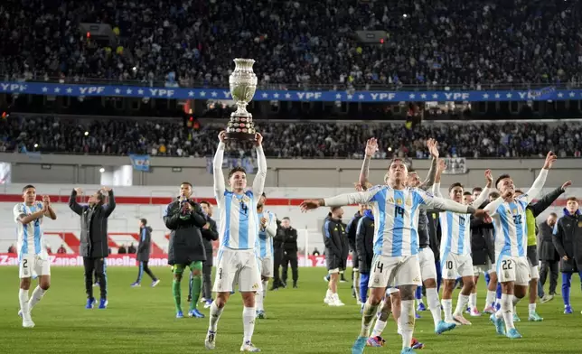 Argentina's Julian Alvarez hoists the 2024 Copa America trophy after a qualifying soccer match for the FIFA World Cup 2026 against Chile in Buenos Aires, Argentina, Thursday, Sept. 5, 2024. (AP Photo/Natacha Pisarenko)