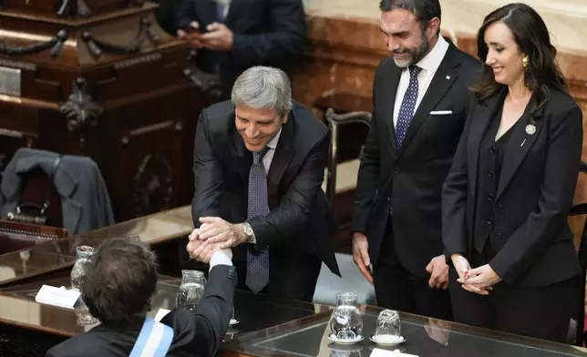 Argentina's Economy Minister Luis Caputo, second from left, greets Argentina's President Javier Milei upon as he arrives at Congress to present the 2025 budget in Buenos Aires, Argentina, Sunday, Sept. 15, 2024. (AP Photo/Natacha Pisarenko)