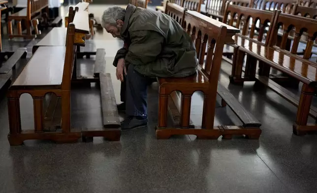 Eduardo Escoz prays at a church on the outskirts of Buenos Aires, Argentina, Thursday, Sept. 12, 2024. Escoz said he pays about $50 a month for a room that he shares with two other people. (AP Photo/Natacha Pisarenko)