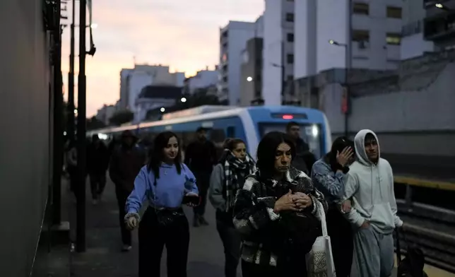 People get off the train, the cost of which is rising, in Buenos Aires, Argentina, Thursday, Sept. 19, 2024. (AP Photo/Natacha Pisarenko)