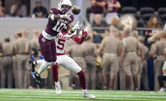 Texas A&amp;M defensive back Dezz Ricks (10) intercepts a pass intended for Arkansas wide receiver Tyrone Broden (5) during the first half of an NCAA college football game, Saturday, Sept. 28, 2024, in Arlington, Texas. (AP Photo/Julio Cortez)