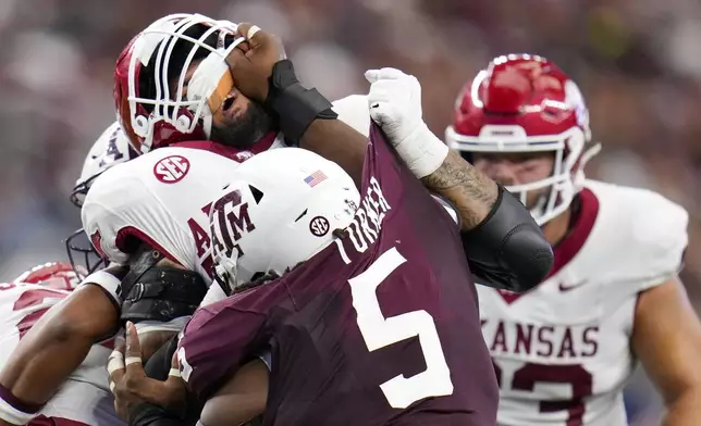 Texas A&amp;M defensive lineman Shemar Turner's hand is seen on the face of Arkansas offensive lineman Keyshawn Blackstock while rushing in during the first half of an NCAA college football game, Saturday, Sept. 28, 2024, in Arlington, Texas. (AP Photo/Julio Cortez)