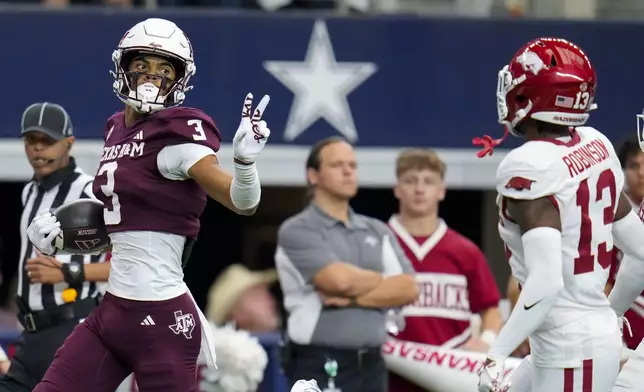 Texas A&amp;M wide receiver Noah Thomas (3) gestures at Arkansas defensive back Marquise Robinson (13) while scoring on a long touchdown reception during the first half of an NCAA college football game, Saturday, Sept. 28, 2024, in Arlington, Texas. (AP Photo/Julio Cortez)