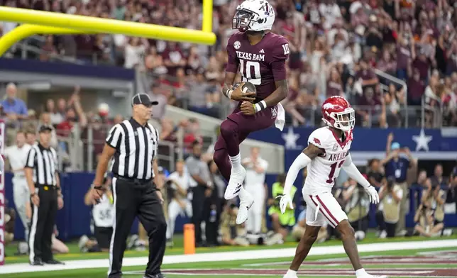 Texas A&amp;M quarterback Marcel Reed (10) reacts in front of Arkansas defensive back Marquise Robinson (13) after scoring on a touchdown run during the first half of an NCAA college football game, Saturday, Sept. 28, 2024, in Arlington, Texas. (AP Photo/Julio Cortez)