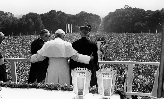 FILE - Pope John Paul II. has his arms around the Primate of Poland, Stefan Cardinal Wyszynski, right, and the Bishop of Czestochowa, Stanislaw Barela, as he faces huge crowd of faithful outside the Jasna Gora monastery, Czestochowa, on June 4, 1979, where the Pontiff holds a pontifical mass on his third day of his nine-day-visit to his homeland Poland. (AP Photo, File)