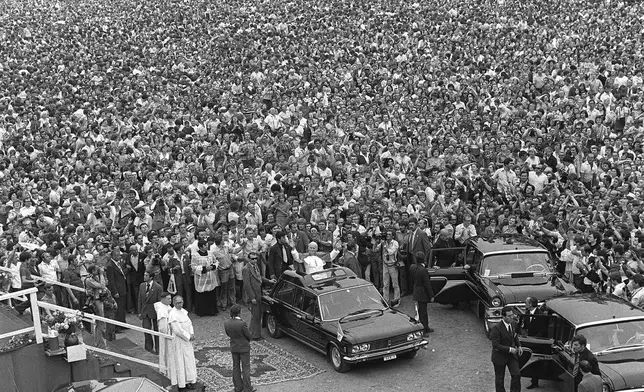 FILE - Pope John Paul II stands in his car as hundreds of thousands of people bid him farewell beneath the Jasna Gora monastery in Czestochowa, Poland, on June 6, 1979. The Pope was greeted by wildly enthusiastic crowds on his first visit to his homeland as leader of the Catholic faith. (AP Photo, File)