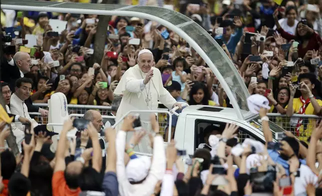 FILE - Crowds cheer as Pope Francis passes by during his meeting with the youth at the University of Santo Tomas in Manila, Philippines, on Jan. 18, 2015. (AP Photo/Aaron Favila, File)