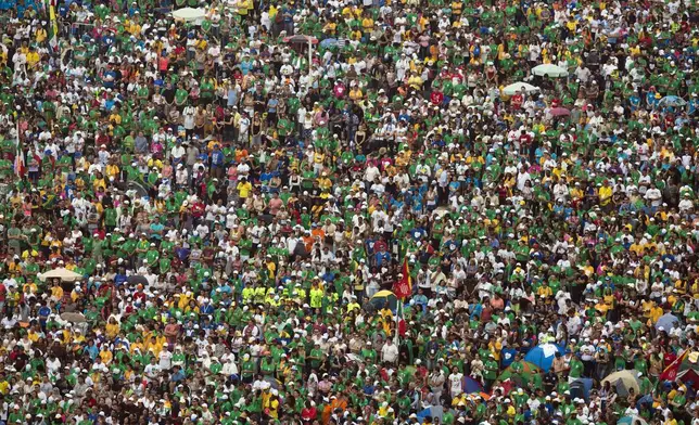 FILE - People attend the World Youth Day's closing Mass celebrated by Pope Francis on the Copacabana beachfront, in Rio de Janeiro, Brazil, on July 28, 2013. (AP Photo/Felipe Dana, File)