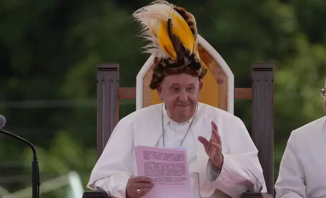 Pope Francis wears a traditional hat during a meeting with faithful in Vanimo, Papua New Guinea, Sunday, Sept. 8, 2024. Despite the considerable security concerns of entering a region torn by tribal rivalries, Francis seemed to relish the jungle visit, perhaps because he felt so much at home. A dozen Argentine missionary priests and nuns have lived in Vanimo with the local community for years and had invited him to come. (AP Photo/Gregorio Borgia)