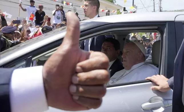 People greet Pope Francis as he travels in a car in Dili, East Timor, Tuesday, Sept. 10, 2024. In East Timor Francis had to negotiate perhaps the most sensitive issue clouding the visit to Asia and Oceania : the case of Bishop Carlos Ximenes Belo, the revered national hero who won the Nobel Peace Prize for his nonviolent independence campaign. (AP Photo/Firdia Lisnawati)