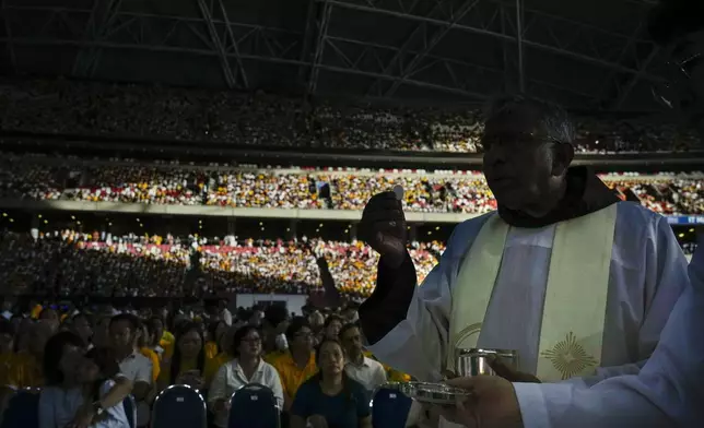 The holy communion is given to the faithful during a mass 'In Memory of the Most Holy Name of Mary' presided over by Pope Francis and celebrated by the Archbishop of Singapore, Cardinal William Goh Seng Chye at the Singapore SportsHub National Stadium, Thursday, Sept. 12, 2024. In Singapore, his final stop of an 11-day trip to Asia and Oceania, Francis once again ditched his remarks when he arrived at the last event, a meeting of Singaporean youth on Friday morning."That's the talk I prepared," he said, pointing to his speech and then proceeding to launch into a spontaneous back-and-forth with the young people about the need to have courage and take risks. (AP Photo/Gregorio Borgia)